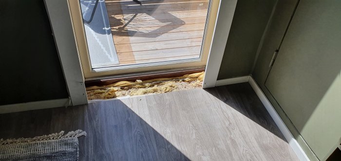Nyinstallerat fönster med ett exponerat golvyta där laminatgolvet inte täcker fram till fönsterkarmen.