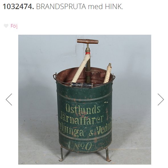 Gammal brandspruta med texten "Östlunds Järnaffärer Falun & Vemdalen" på en grön hink.