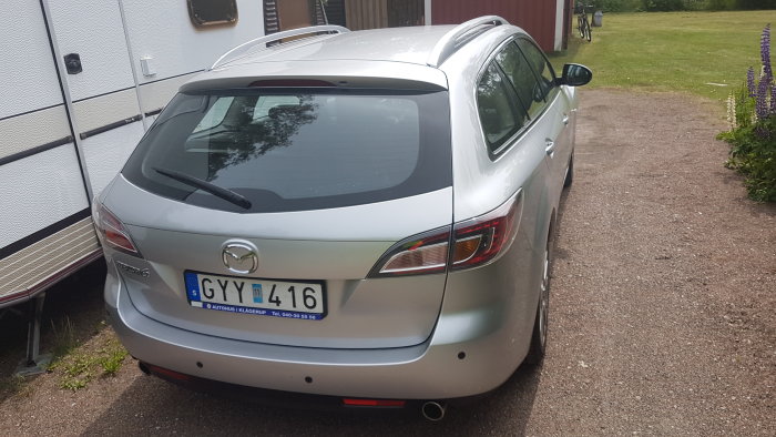 Bakre delen av en silverfärgad Mazda 6 med en knappt synlig dragkrok.