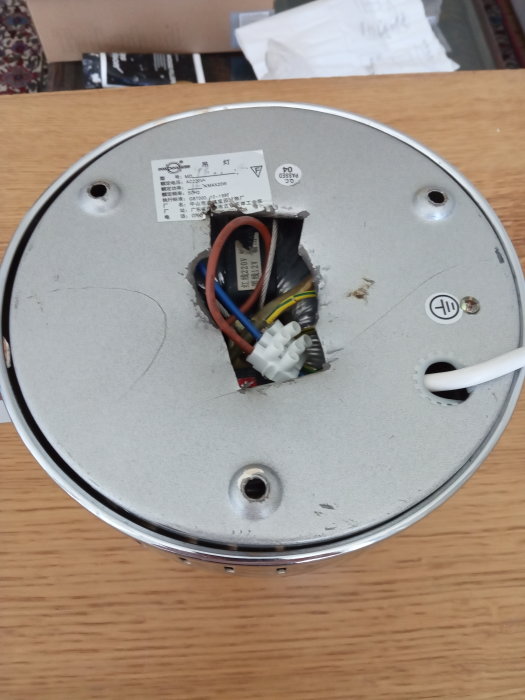 Baksidan av en taklampa med elektrisk anslutning och hål för infästning i taket.