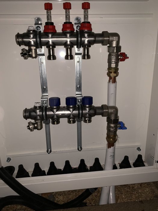 Nyinstallerad fördelare med kopparledningar och synliga skarvar, inklusive två 90-gradersböjar, i ett renoveringsprojekt.
