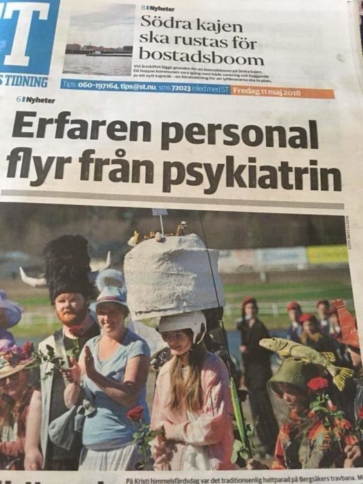 Personer i udda huvudbonader deltar i en hattävling under en traditionell fest.