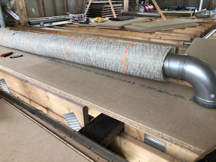 Brandisolerad imkanal med folieklätt material ligger på en arbetsbänk under renovering.