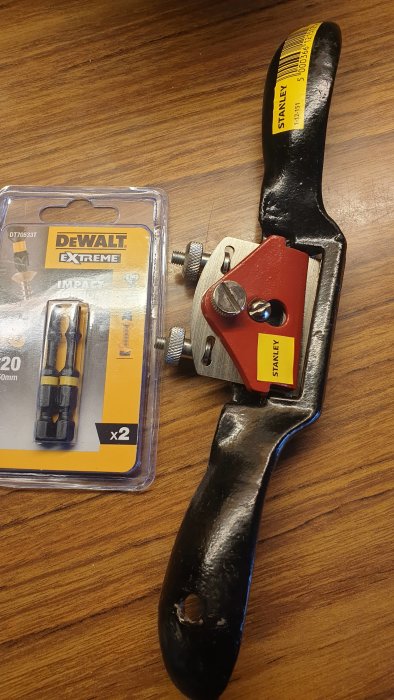 Ny spånhyvel och en förpackning ersättningsborrar på ett träbord.