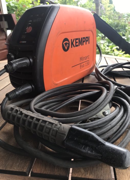 Kemppi Minarc Evo 150 svetsmaskin med svetselektroder och kablar på träunderlag.