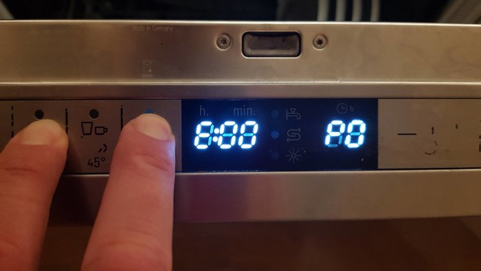 Display av diskmaskin som visar koder C:00 och E:00 med ett finger som pekar på panelen.