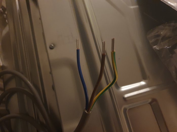 Elektriska kablar för en byggnadsrenovering, med en brun, blå och gul/grön tråd som sticker ut.