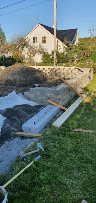 Nyinstallerade tunga trappsteg i granit med 5mm lutning i en trädgård under konstruktion.