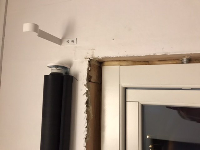 Nyinstallerat fönster i husvägg med synlig regel och isolering där den gamla karmen tagits bort.