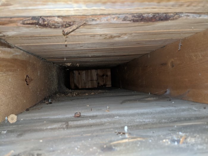 Inspektionsvy av underifrån balkong med råspont och synliga träbjälkar, eventuella vattenskador ej synliga.