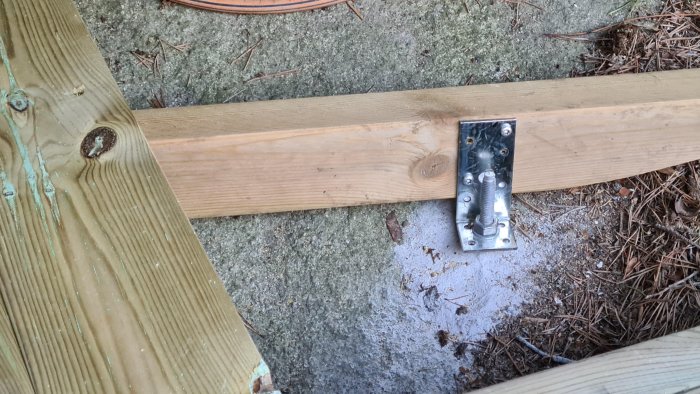 Expanderbult M10x120 fäst i betong med vinkelbeslag kopplat till träreglar i byggprojekt.