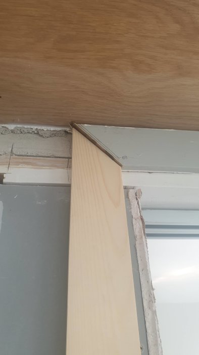 Omonterat dörrfoder med millimeterskillnader vid karm och vägg.
