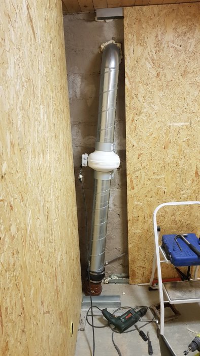 Temporär installation av avlopp med 15 graders böj och gummiövergång kopplad till spiro-dubbelnippel i ett byggprojekt.