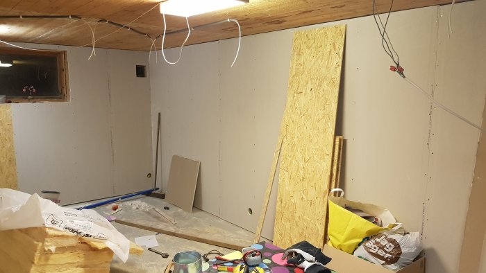 En oavslutad renovering med gipsskivor, isoleringsmaterial och byggmaterial på golvet.