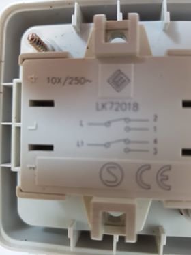 Baksidan av en ljus strömbrytare med ett kopplingsschema märkt 1,2,3,4,L, L1/N och CE-märkningen synlig.