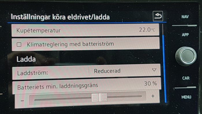 Bilens infotainmentsystem med inställningar för eldrift och laddning, visande "Reducerad" laddström.