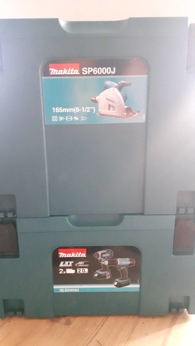 Makita-verktyg i staplade lådor: sänksåg SP6000J överst, skruvdragare och slagskruvdragare nedtill.