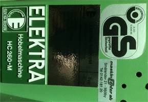 Etikett på en Elektra HC 260_M planhyvel med GS-certifiering, fokus på trög svart startknapp.