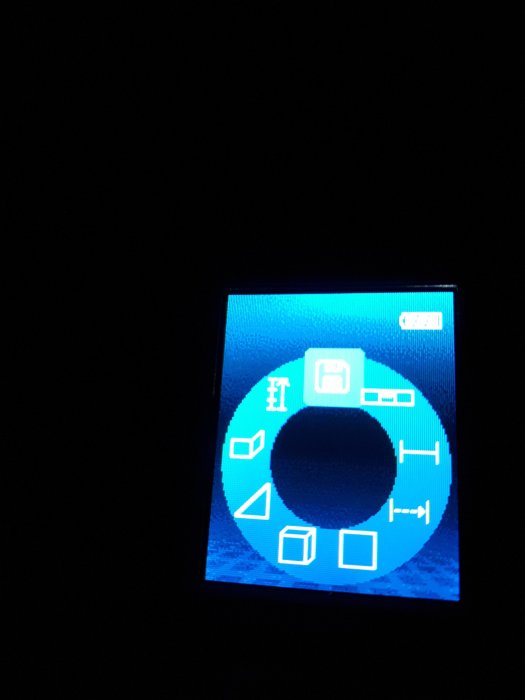 Bild på en upplyst digital mätarens display med olika symboler och en markerad diskettikon.