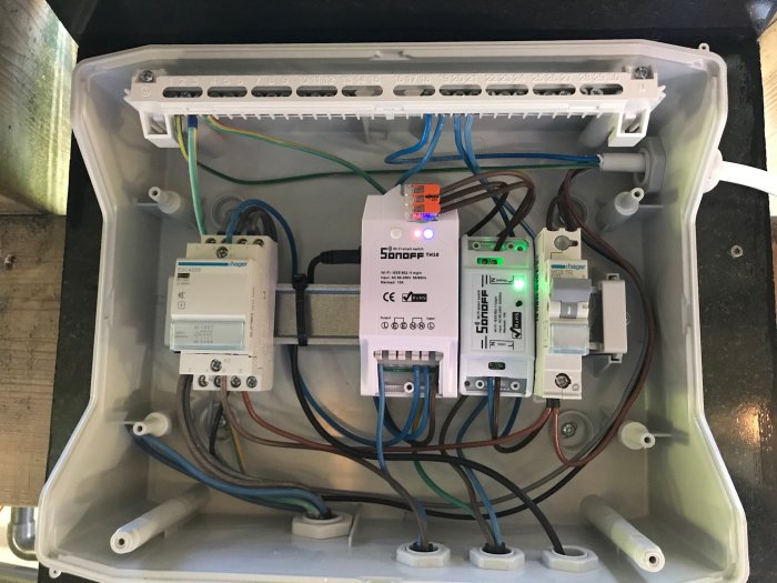 Elektriskt skåp med Sonoff smart hem-automationsmodul och andra kopplade elektriska komponenter.