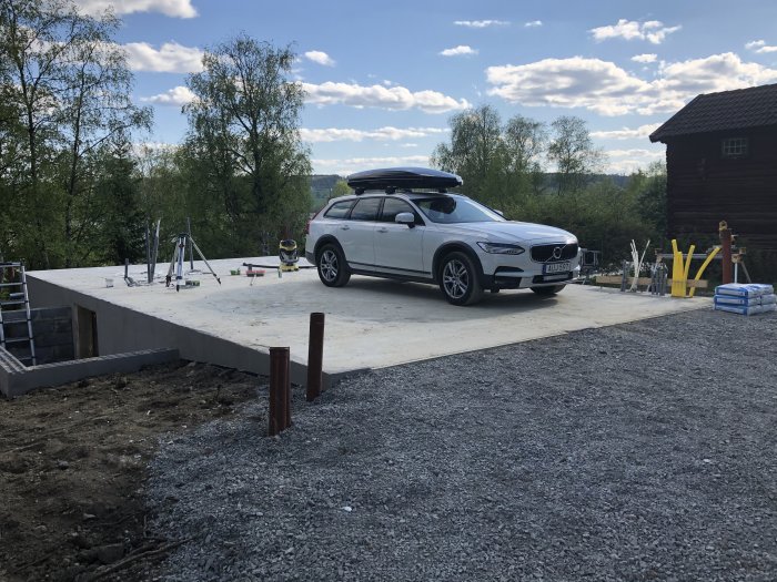 Nybyggt betongvalv med vit bil parkerad och byggmaterial i förgrunden.
