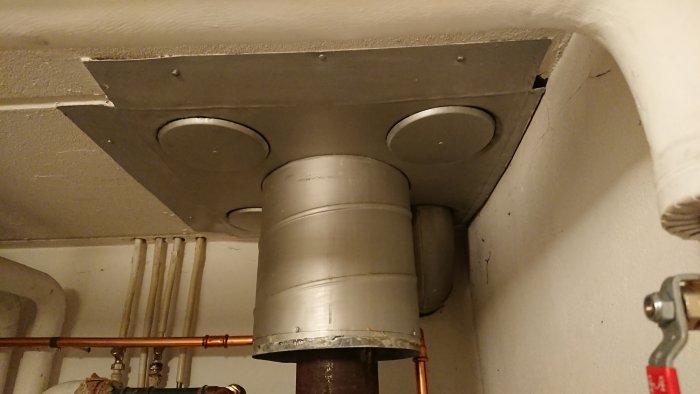 Metallrör installerade för FTX-system genom tak och väggar i en källare.