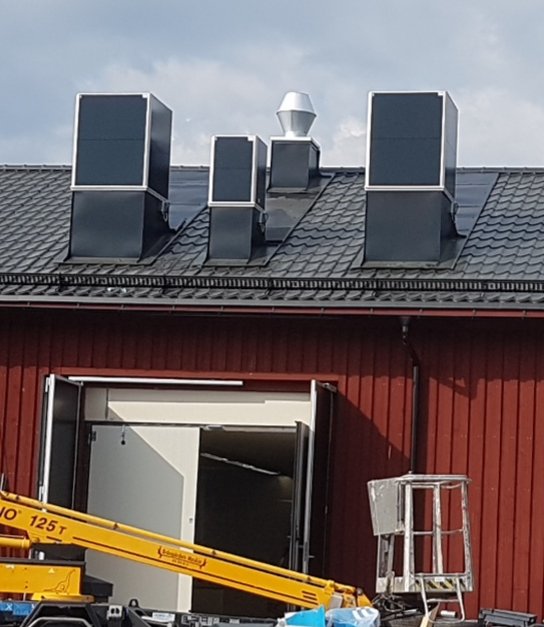 Svarta lådor monterade på tak som är en del av tyst ventilationssystem från Ebm Papst modell MXRC.