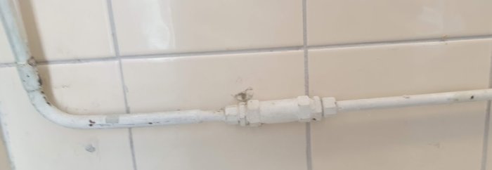 12 mm kallvattenrör som matas från höger och övergår till större dimension vid en koppling till vänster på vita kakelväggen.