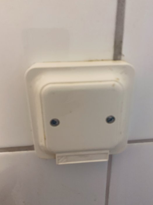 Vitt eluttag på vägg utan synlig kontakt, förberett för installation av tvättmaskin.