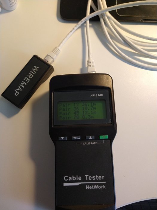 Avancerad nätverkskabeltestare med display visar längd och status för olika par i ethernetkabel.