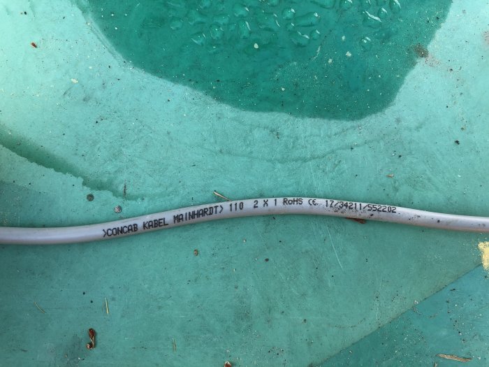 Kabel markerad med "CONCAB KABEL MAINHARDT 110 2 x 1 RoHS" på en grön bakgrund.
