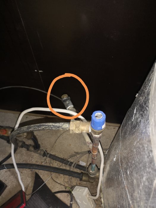 Vattenuttagspunkt markerad med en cirkel efter hydroforen med rör och anslutningar i ett teknikrum.