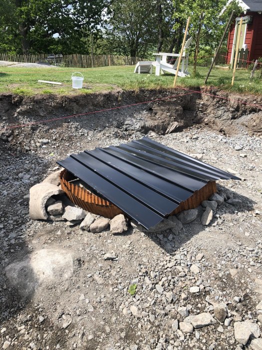 En plåt täcker stenblock i grushål med borrade hål för syretillförsel vid eldning för att spränga sten.