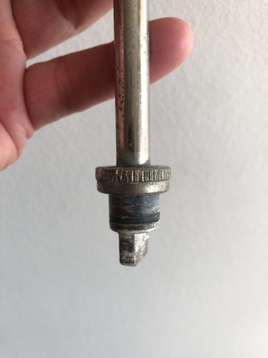 Hand håller en äldre IDO-ventil med synlig o-ring i behov av utbyte.