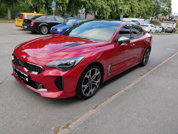 Röd sportbil parkerad på gatan, V6 3.3L dubbla turbo, tänkt att trimmas till 450 HK.