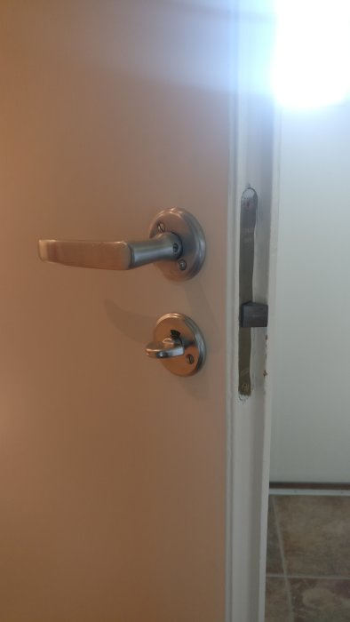 Innerdörr med handtag och låskista som illustrerar problemet som beskrivs av användaren.