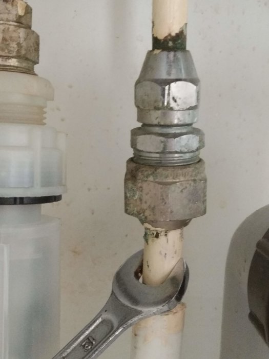 Vattenkoppling med stelt kopparrör och justerbar skiftnyckel vid VVS-arbete under renovering.