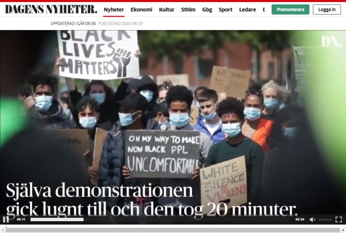 Demonstranter med ansiktsmasker håller upp plakat under en fredlig protest.