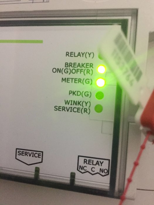 Närbild på en elpanel med gröna lysdioder och texten "RELAY", "BREAKER ON/OFF", "METER".