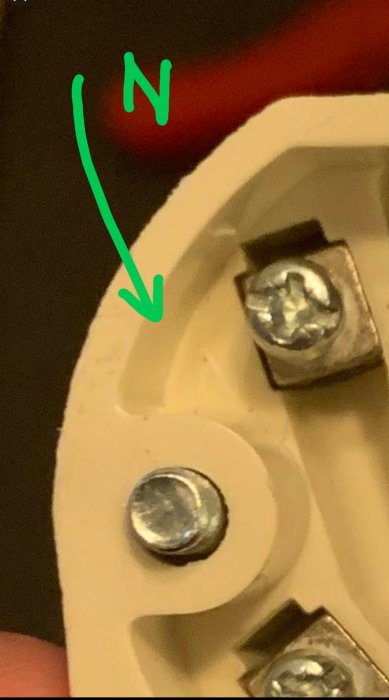 Närbild på ett eluttag med markerad nollans position och skruvar, märkt "N".