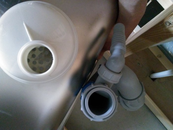 Översiktsbild av ett vattenlås anslutet till ett avloppsrör med undring om det behövs gummibricka för tätning.
