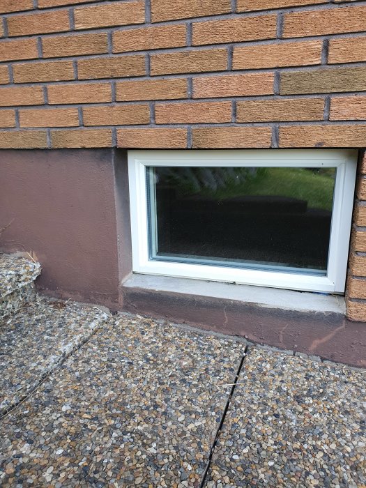 Nytt aluminiumfönster installerat i en murad fasad med delvis putsad leca och tegel, utan synlig trekantslist eller plåt.