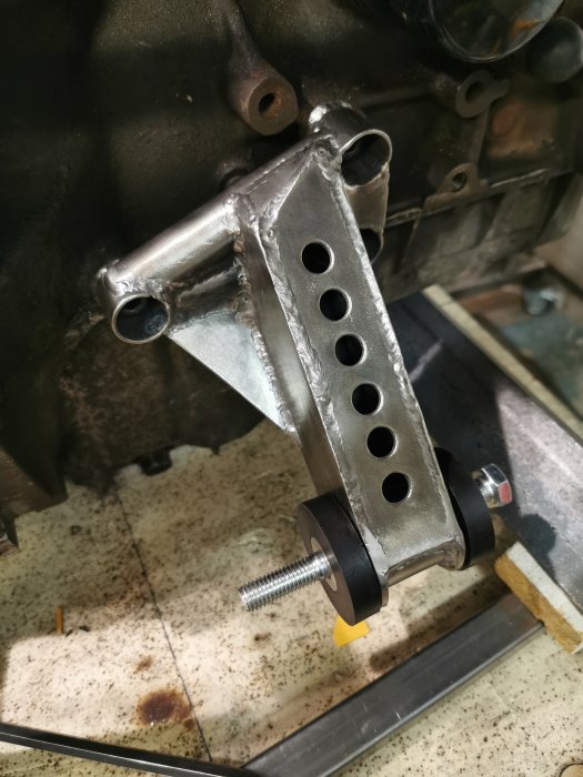Nygjorda motorfästen i metall monterade på motorblock, synliga svetsfogar och justerbara delar.