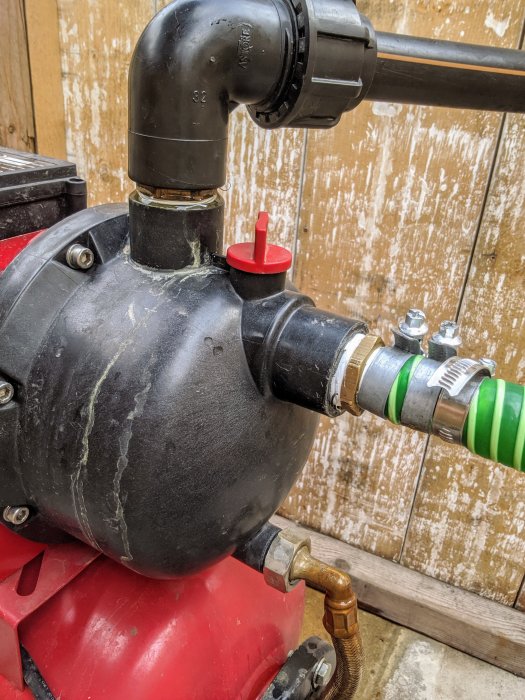Pump med anslutna rör och slangar, indikation på reparation vid en tätningspunkt.