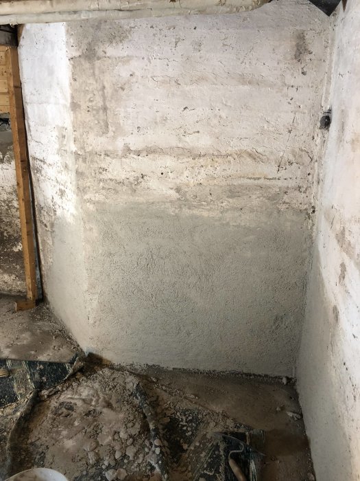 Ommålad hörna av en betongvägg i ett renoveringsprojekt med synliga spår av byggarbete.