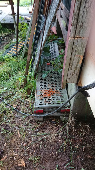 Metallramper med hålmönster liggande på marken, eventuellt delar till transportlastbil.