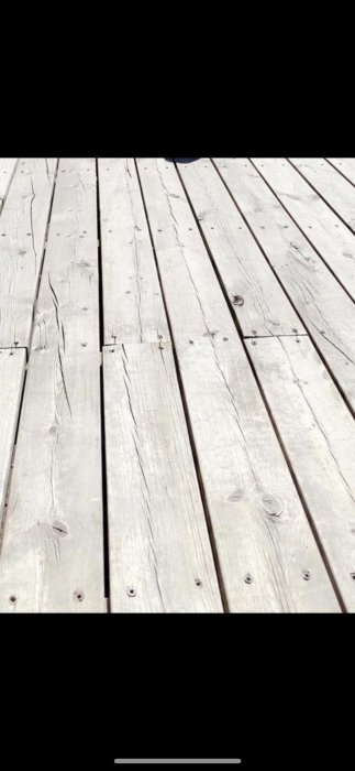 Nötta trätrallbrädor i behov av underhåll och behandling.