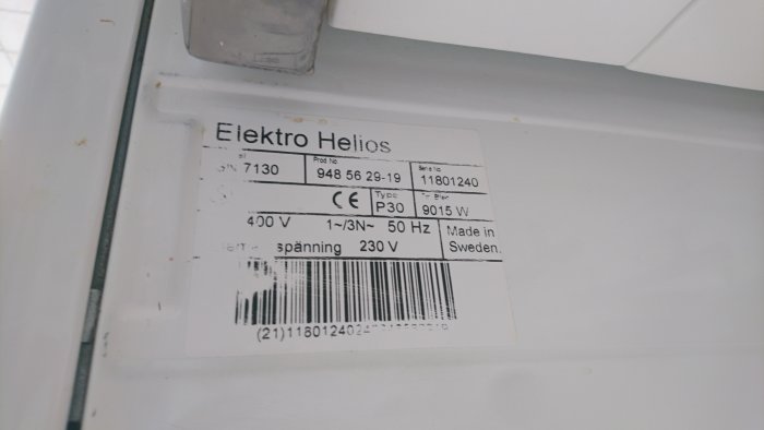 Etikett på en Elektro Helios spis med specifikationer för spänning och effekt.