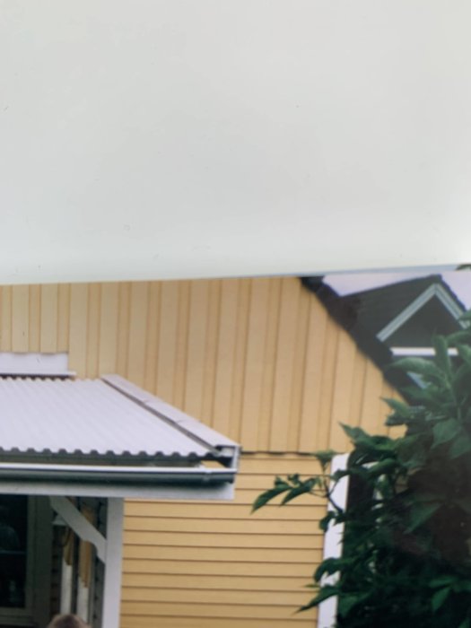 Altantak med synligt vinkeljärn och lösa skruvar, vidkänning av husfasad.