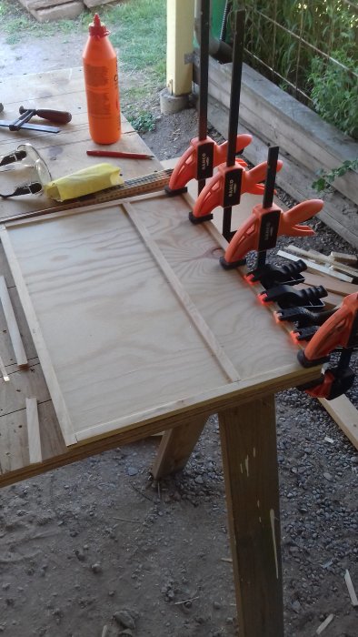 Hantverksprocess av furuplywood för en anpassad 'chuck box' verktygslåda klämd på ett arbetsbord.